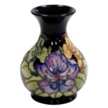 A Moorcroft pottery vase, circa 1996, decorated with flowers against a dark blue ground, impressed a