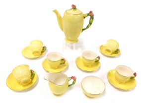 An early 20thC Royal Winton pottery part coffee service, yellow ground, with rose moulded handles an
