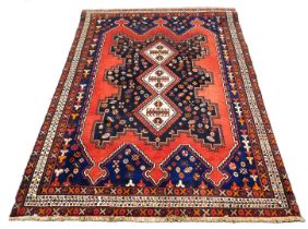 A Turkish design rug, with blue multi gul central field, on a red ground, 237cm x 159cm.