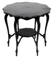 An Edwardian ebonised window or occasional table, the circular top with a shaped moulded edge, on le