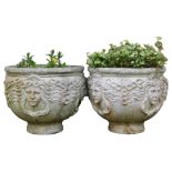 A pair of reconstituted stone garden urns, each decorated with chains etc, 46cm high, 52cm wide.