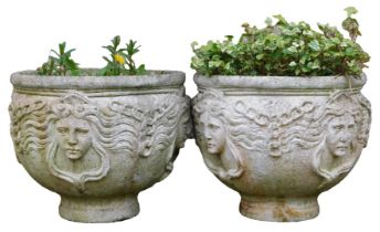 A pair of reconstituted stone garden urns, each decorated with chains etc, 46cm high, 52cm wide.