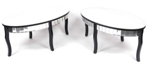 A pair of modern glass and ebonised coffee tables, each with an oval top above a glass panelled frie