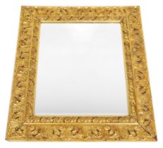 A gilt wall mirror, with moulded decoration of leaves, etc., surrounding a bevelled plate, 87cm high