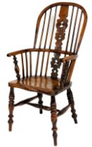 A yew and elm Windsor chair, with a pierced splat, spindle turned rails and a solid seat, on turned
