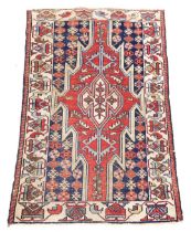 A Persian Kazak style rug, with a design of multicoloured geometric devices, one wide and one narrow