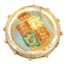 A Queen Victoria jubilee head coin 1887 with shield back, enamel inlaid, in a 9ct gold and glass bac