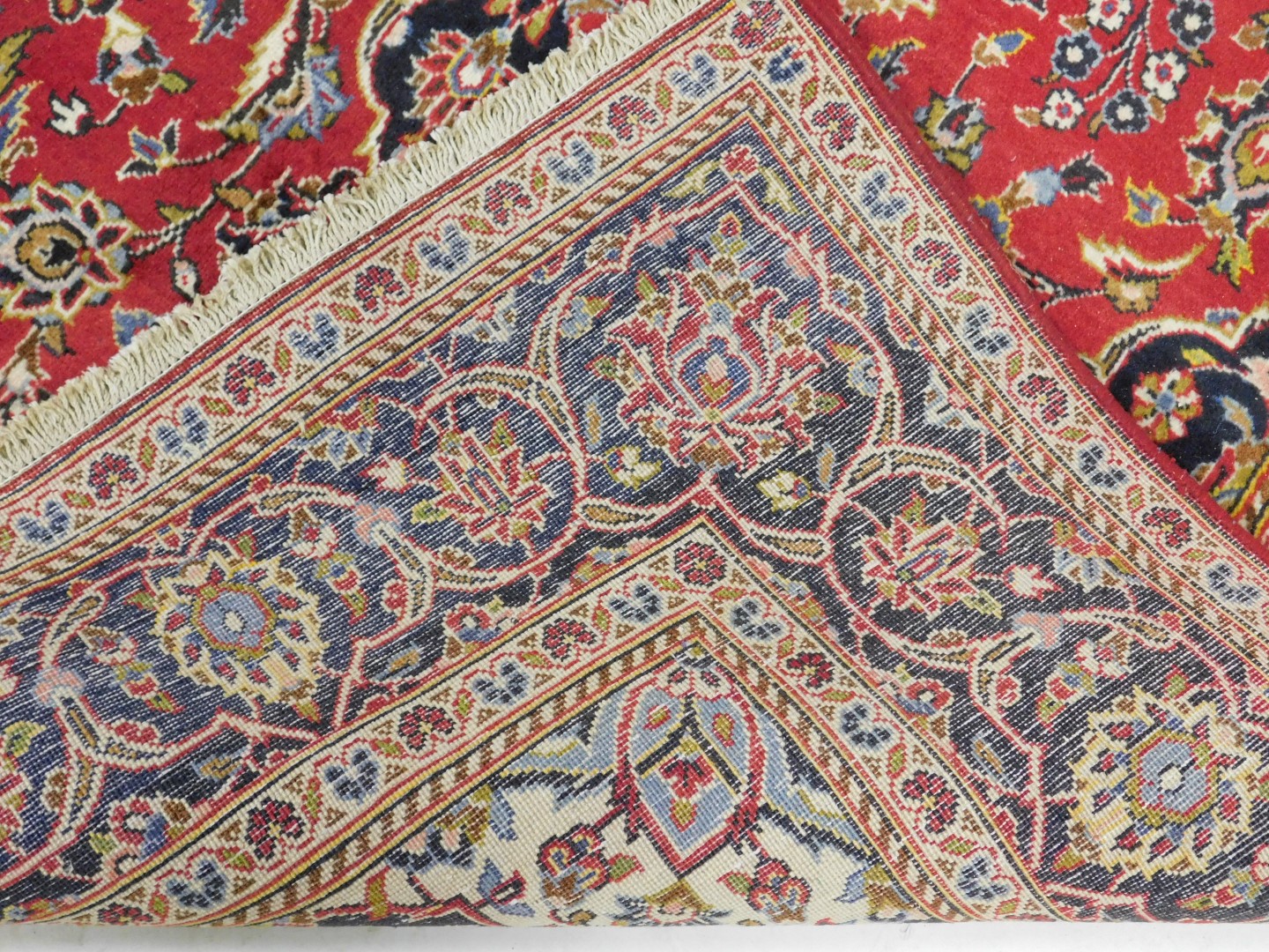 A Persian rug decorated with leaves and scrolls, on a red ground, with one wide and two narrow borde - Image 3 of 3