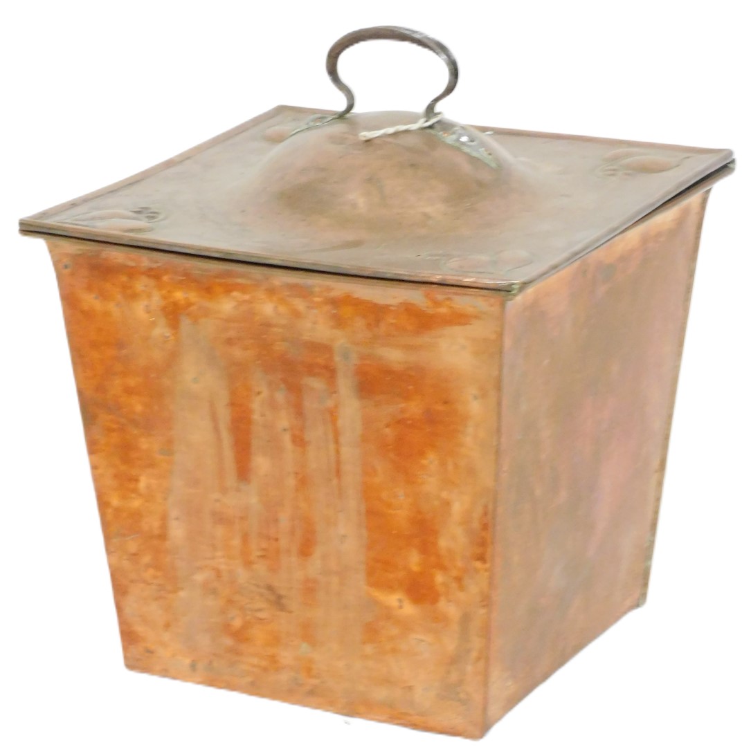 A Victorian Arts and Crafts copper coal box, with a cast iron handle, the hinged lid embossed with s