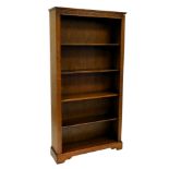 An oak open bookcase, with demi lune frieze, fluted sides and four adjustable shelves, 195cm high, 1