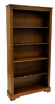 An oak open bookcase, with demi lune frieze, fluted sides and four adjustable shelves, 195cm high, 1