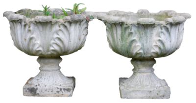 A pair of reconstituted stone garden urns, each cast with leaves, on a square base, 43cm high, 48cm