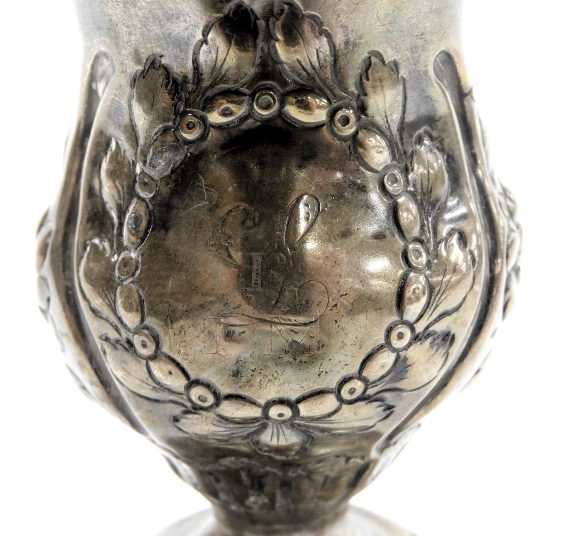 A George III silver cream jug with a later loaded base, of baluster form, embossed with flowers, cir - Image 2 of 3