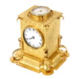 A Victorian brass cased desk clock, of Gothic form, with circular dial bearing Roman numerals, the t