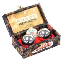 A pair of Chinese iron Baoding exercise balls with instructions, boxed.