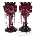A pair of late 19thC ruby glass lustres, with enamel decoration of floral swags, with prismatic clea