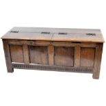 An oak and pine coffer, with a quadruple panelled front, on stiles, 69cm high, 185cm wide. (AF)