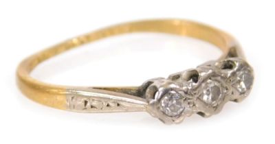 An 18ct gold platinum and diamond three stone ring, in an illusion setting, size J, 1.6g all in.