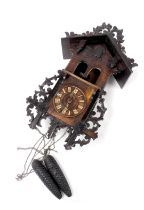 A late 19thC continental stained pine cuckoo clock, the dial bearing Roman numerals, with a carved a