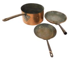 A Victorian copper saucepan, with a cast iron handle, the body stamped AH, 29cm wide, together with