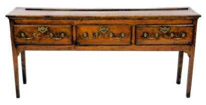 A late 18thC oak dresser, the rectangular top with a raised recess for plates, above three drawers,