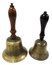 An early 20thC brass school bell, with a turned wooden handle, 25.5cm high, and further bell with an
