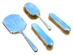 A George V silver and blue guilloche enamel four piece dressing table set, comprising a hairbrush, a