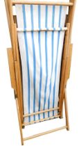 A pair of beech deck chairs, each with striped seats.