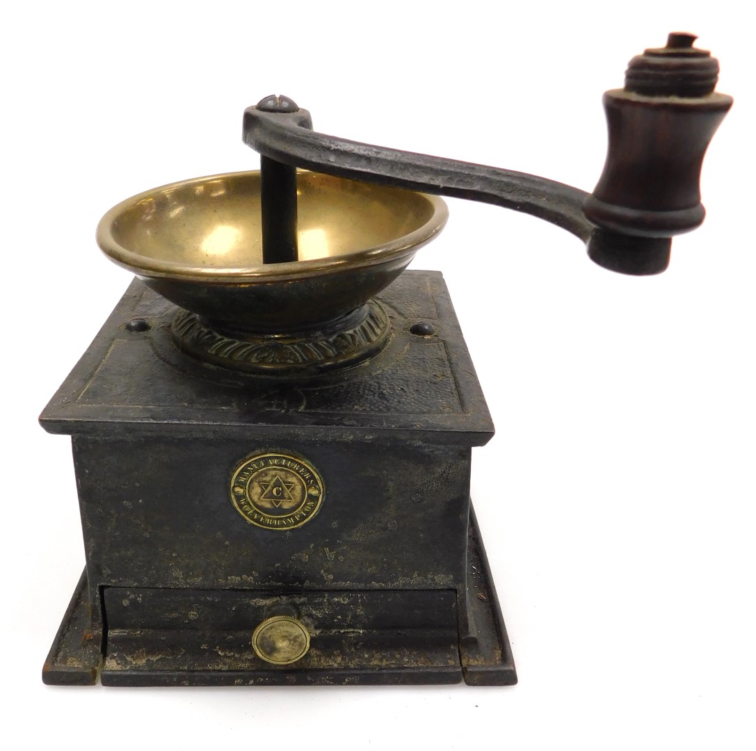 A Victorian cast iron and brass coffee grinder, with a frieze drawer and circular plaque marked manu