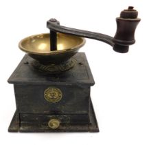 A Victorian cast iron and brass coffee grinder, with a frieze drawer and circular plaque marked manu