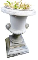 A stone campana urn with scroll handles, reeded body, and stepped base, in two parts, 99cm high.