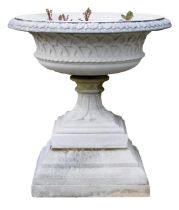 A reconstituted stone garden urn, circular top with a leaf cast border, tapering column, and a squar