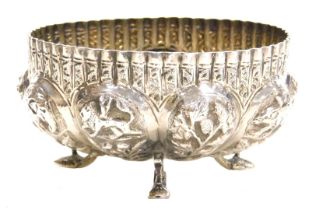 An early 20thC Indian sugar bowl, of semi fluted form, repoussé decorated with wild animals and tree