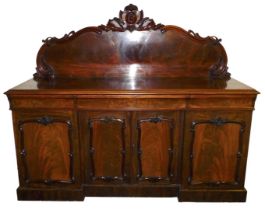 A Victorian mahogany break front sideboard, with a carved back over one long and two short cushion d