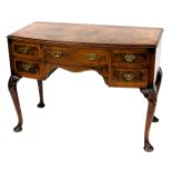 A 1920s cross banded figured walnut bow front dressing table, with frieze drawers and cabriole legs