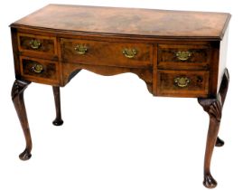 A 1920s cross banded figured walnut bow front dressing table, with frieze drawers and cabriole legs