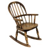 A late 19th/early 20thC ash and elm child's Windsor rocking chair, with spindle turned back, solid s