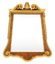 A figured walnut and gilt wall mirror, in early 18thC style, with a swan neck pediment decorated wit