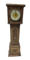 A late 19thC oak cased miniature long case clock, the circular brass dial with enamel chapter ring b