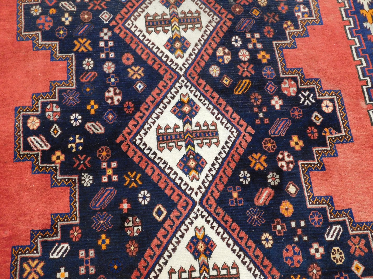 A Turkish design rug, with blue multi gul central field, on a red ground, 237cm x 159cm. - Image 2 of 3