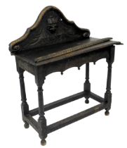 A stained oak and carved hall table, with galleried back, raised on turned supports joined by a stre