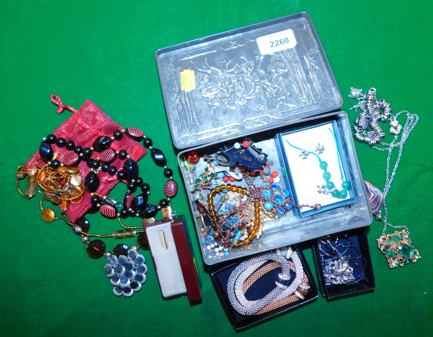 Costume jewellery, contained in an embossed tin, to include bangles, necklaces, etc.