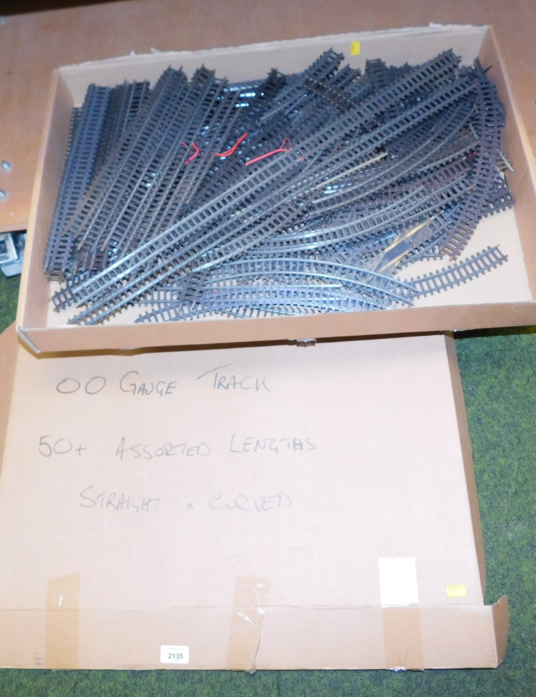 A box with a large selection of OO gauge railway track, parts include straight rail and curved rail,