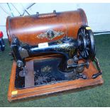 A manually operated Singer sewing machine, in a wooden case.