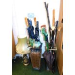 A wicker stick stand, with sticks and umbrellas, 60cm high, 24cm wide, 24cm deep, a brass stick stan