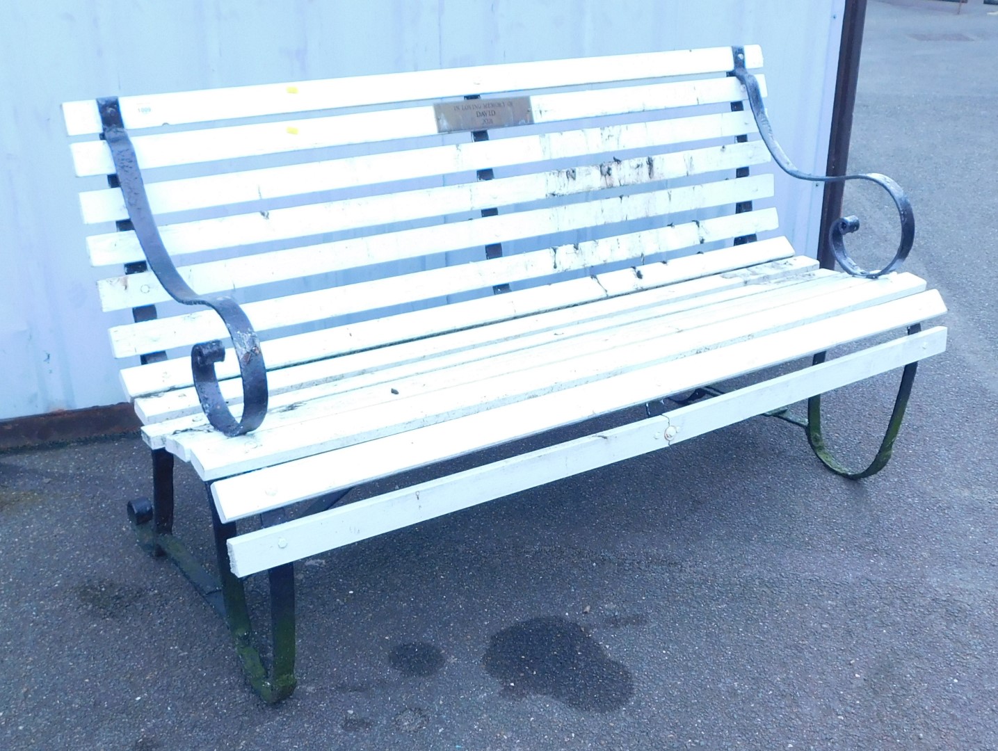 A white painted wooden garden bench with metal ends.