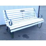 A white painted wooden garden bench with metal ends.
