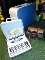 A cased portable typewriter, a suitcase and two bagged bowling balls.