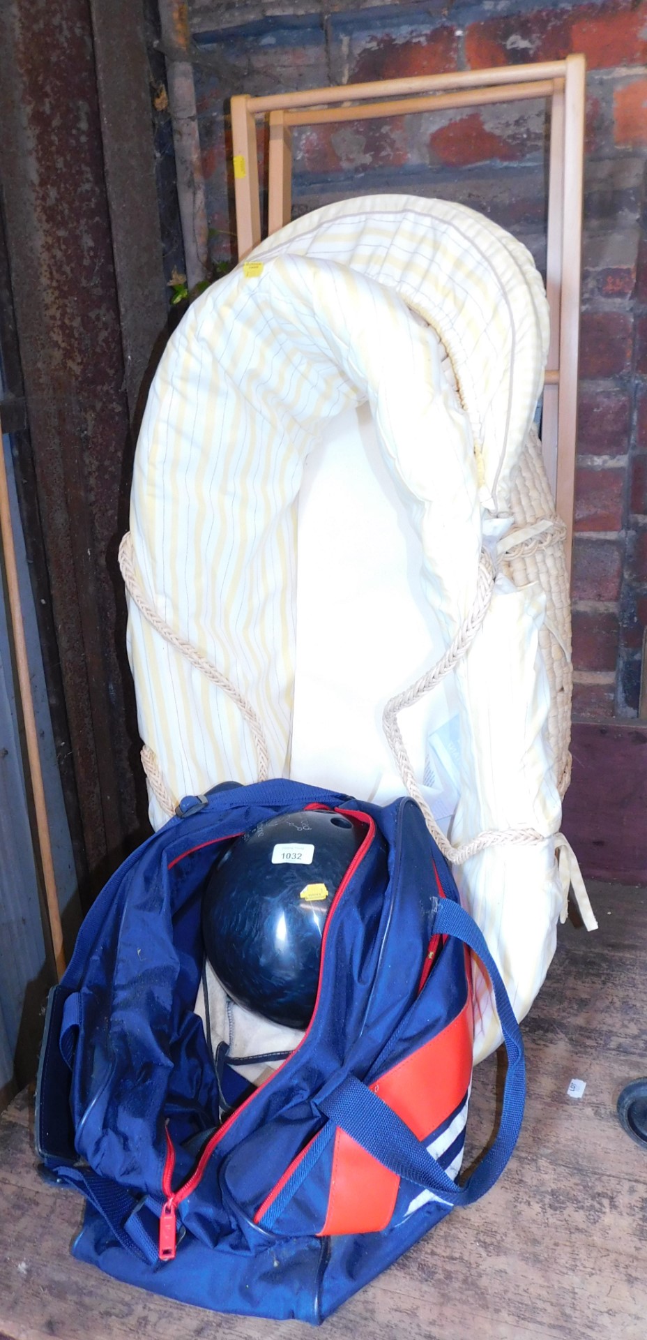 A baby Moses type basket, on an A frame stand, together with a bowling ball in canvas case.
