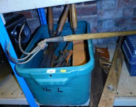 A box containing tools, including garden saws, vices, clamps and a hand drill.